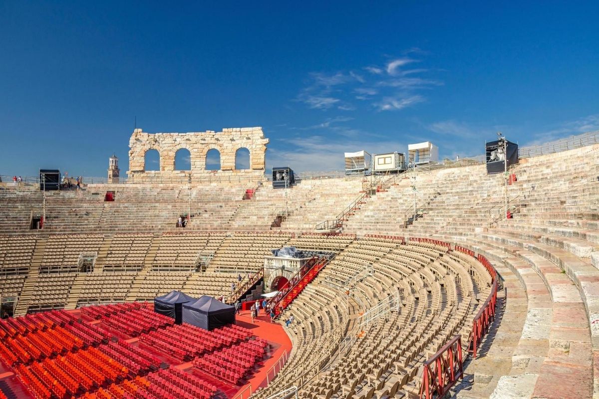 Interno dell'Arena di Verona durante un evento, includi dettagli sull'atmosfera